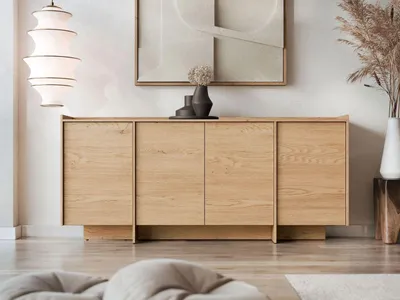 A modern living room with a wooden sideboard, a large abstract painting on the wall, and a floor lamp.