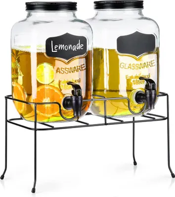 Two glass beverage dispensers with spigots on a black metal stand.