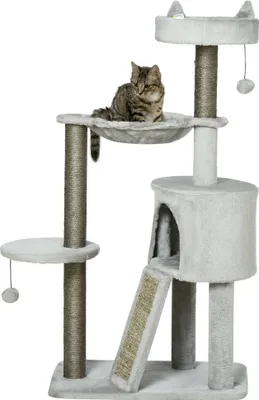 A cat sits on a multi-level cat tree with scratching posts, a hammock, and a hideaway.