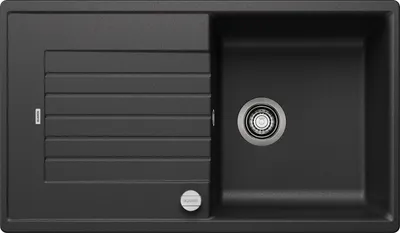 A top-down view of a black kitchen sink with a drainboard.