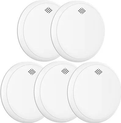 A group of five white smoke detectors are arranged in a staggered pattern against a white background.