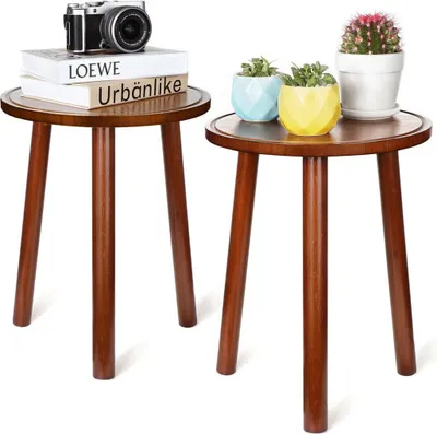 Two wooden side tables with decorative items on top.