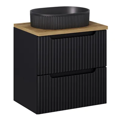A black bathroom vanity with a wooden top and a black sink.
