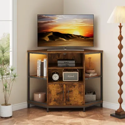 A corner TV stand with a TV on top, placed in a room with a window and a floor lamp.