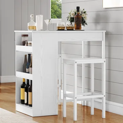 A white bar table with shelves and two white bar stools, set up in a room with wood flooring and paneled walls.