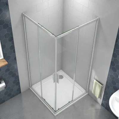 A modern bathroom corner with a glass shower enclosure and a white shower tray.