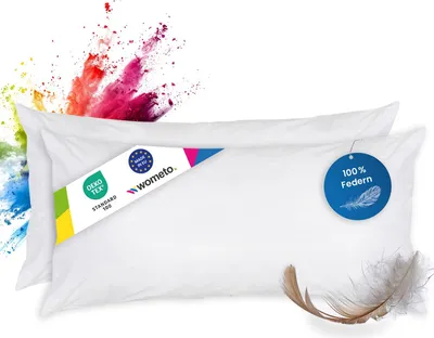 Two white feather pillows are shown with colorful powder exploding behind them.