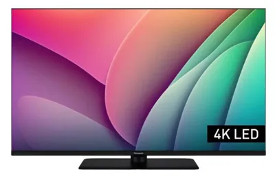 A Panasonic TV is displayed on a stand with a colorful abstract background.