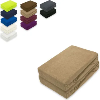 A stack of folded fitted sheets in a sand color is shown in the foreground, with smaller stacks of fitted sheets in various colors arranged in the background.