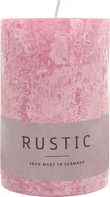 A close-up studio shot of a pink pillar candle with a label.