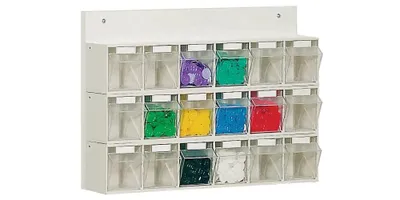 A white wall-mounted organizer with 18 clear compartments, each containing colored material.