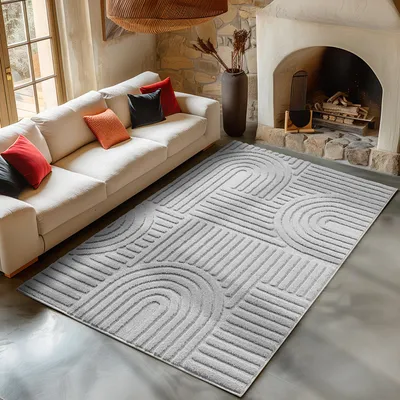 A living room scene with a sofa, fireplace, and a rug.