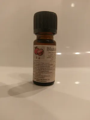 Kleine braune Flasche mit einem schwarzen Verschluss. Auf dem Etikett steht "Blutorange".

