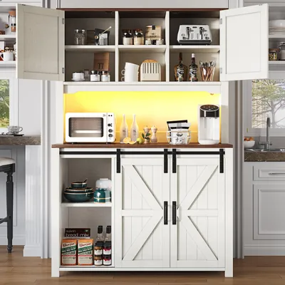 A white kitchen sideboard with sliding barn doors and open shelving, displaying kitchen appliances and decor.