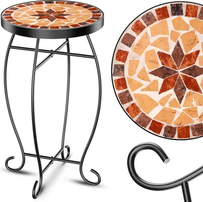 A mosaic plant stand with a circular table top made of mosaic tiles in shades of brown, orange, and tan, set on a black metal frame.