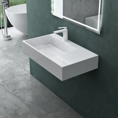 A modern bathroom with a wall-mounted sink and a freestanding bathtub.
