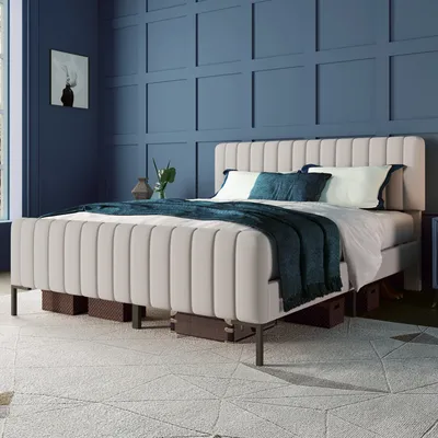 A bedroom scene with a bed as the main focus, decorated with pillows and a throw blanket. The walls are paneled and painted a deep blue.