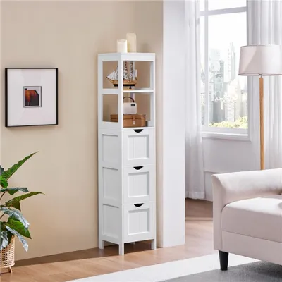 A white corner storage cabinet with shelves and drawers is shown in a room with a window and a floor lamp.