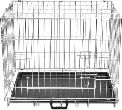 A metal dog crate with a black plastic tray.