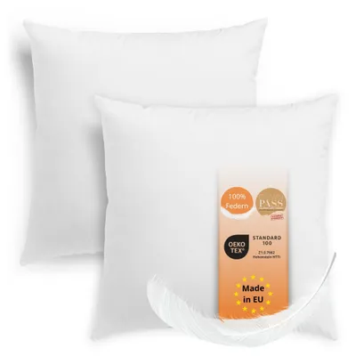 Two white pillows are shown on a white background, with a feather and a product certification tag.