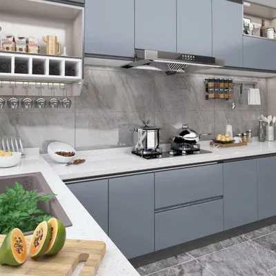 A modern kitchen interior with gray cabinets and a marble backsplash.