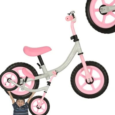 A child is holding a balance bike.