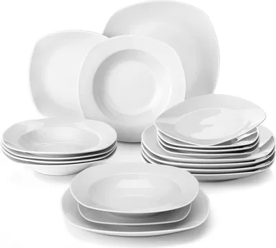 A collection of white ceramic plates and bowls arranged on a white background.