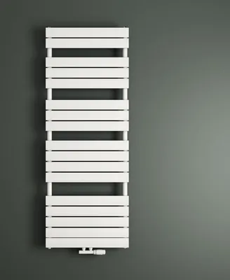 A white radiator is mounted on a dark gray wall.