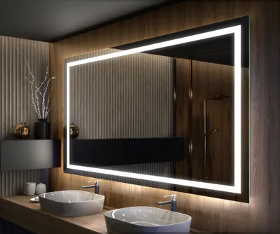 A modern bathroom with two sinks and a large illuminated mirror.