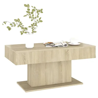 A coffee table with a vase of plants and a magazine on top.