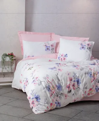 A floral patterned duvet cover set with pink pillowcases is displayed on a bed.