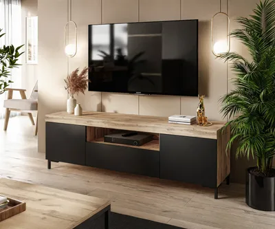 A modern living room with a TV stand and a large television mounted on the wall.