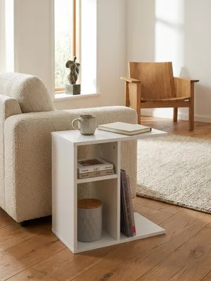 Kompakter Sofatisch in Weiß, der platzsparend über die Sitzfläche eines taupefarbenen Sessels geschoben ist in einem minimalistischen Interior._#sku_SAFWL5.315#