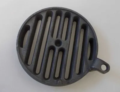 A round cast iron grate on a white background.