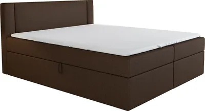 A brown boxspring bed with a white mattress on top, shown from a diagonal angle.