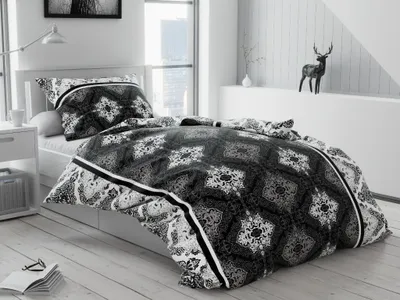 A bedroom scene with a bed made up with gray cotton bedding.
