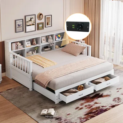 A white daybed with storage drawers and a bookshelf headboard, set up in a room with decorative items on the wall and a rug on the floor. An inset shows a close-up of a power outlet with USB ports.