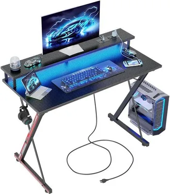 Immagine prodotto di Ibenzoa®: Scrivania da gaming ergonomica con illuminazione LED, barra di alimentazione integrata con prese USB/Type-C, ampia superficie per monitor e struttura a forma di X