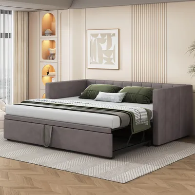A gray sofa bed is shown in a bedroom setting with decorative shelves and artwork on the wall.