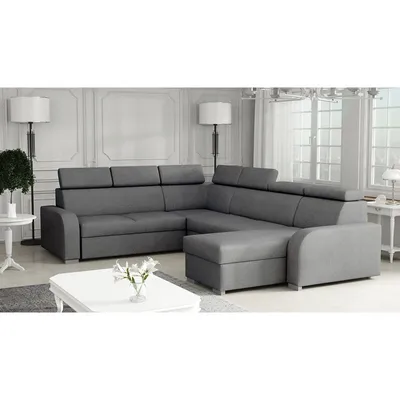 A grey sectional sofa with adjustable headrests is shown in a well-lit room with decorative molding on the walls.