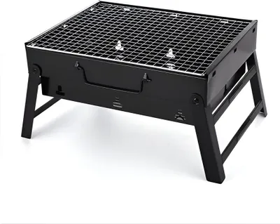 A black, foldable charcoal grill with a metal grate, shown from a slightly elevated front-left angle against a white background.