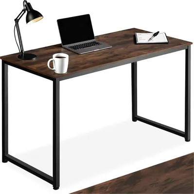 A desk with a laptop, mug, and lamp.