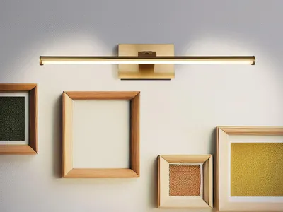 A wall-mounted light fixture above several picture frames.