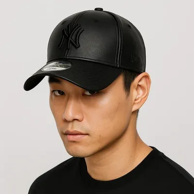A close-up portrait of a man wearing a black New York Yankees baseball cap.