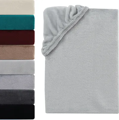 A stack of folded blankets in various colors next to a larger folded blanket with a corner showing.