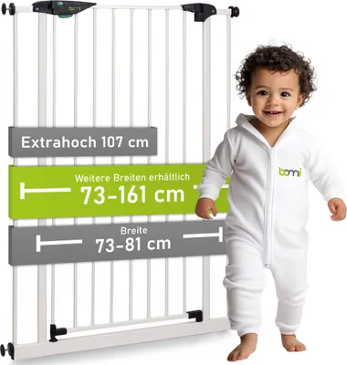 A baby in a white jumpsuit stands next to a white baby gate with text overlays indicating dimensions and features.