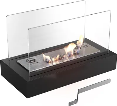 A black tabletop fireplace with glass wind guards and a metal burner with flames.