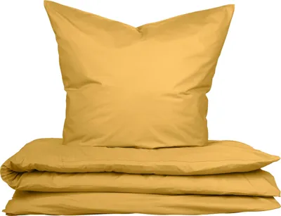 A folded duvet and a pillow, both in a mustard yellow color, are stacked on top of each other against a white background.