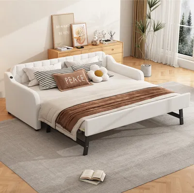 A white sofa bed is shown in a room with a wooden dresser and a plant.