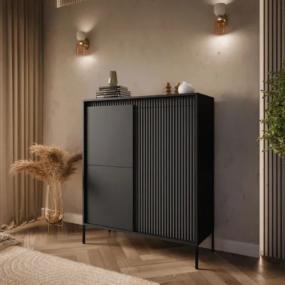 A modern black dresser with fluted doors and a sliding panel, placed in a well-decorated room with ambient lighting and decorative elements.